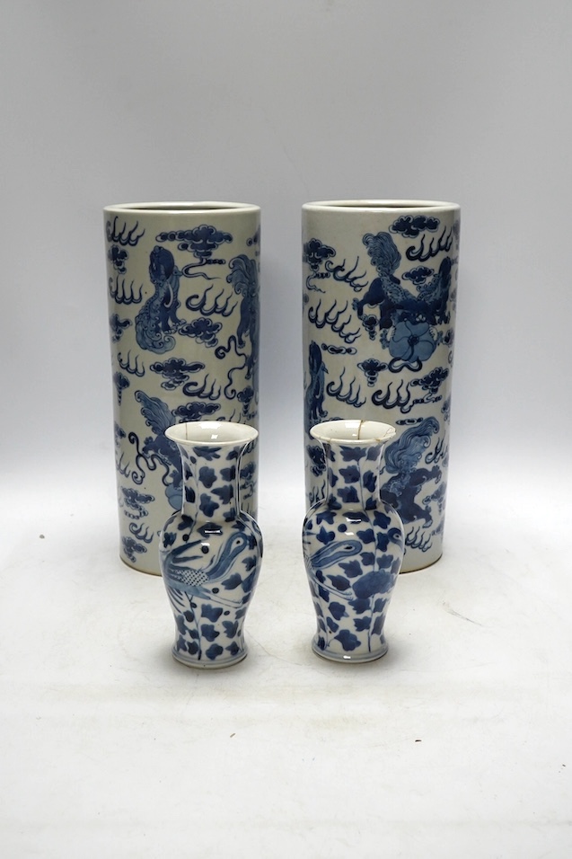 A pair of Chinese blue and white cylindrical brushpots and a smaller pair, tallest 29cm. Condition - both smaller vases with heavy repairs